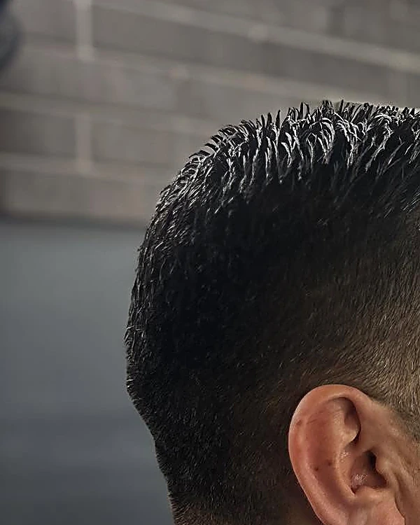 Corte clásico peinado hacia atrás con los costados rebajados, visto desde atrás