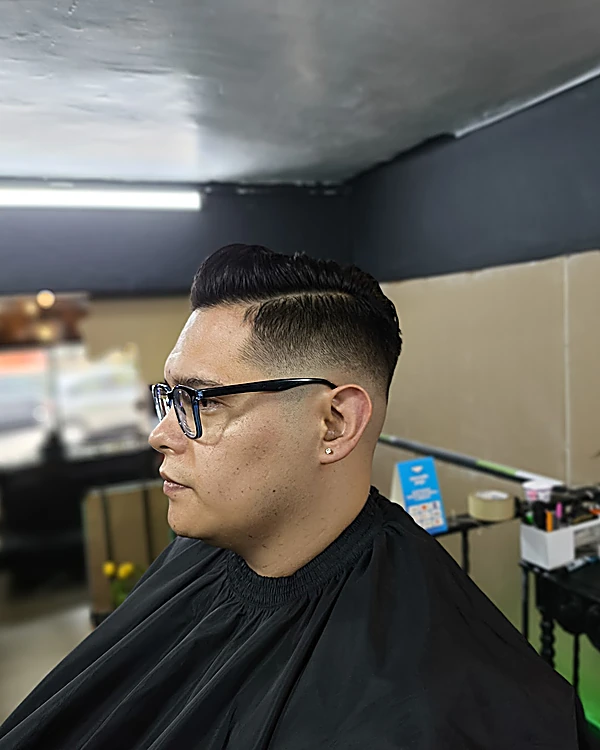 Corte con degradado lateral y raya marcada, visto de perfil