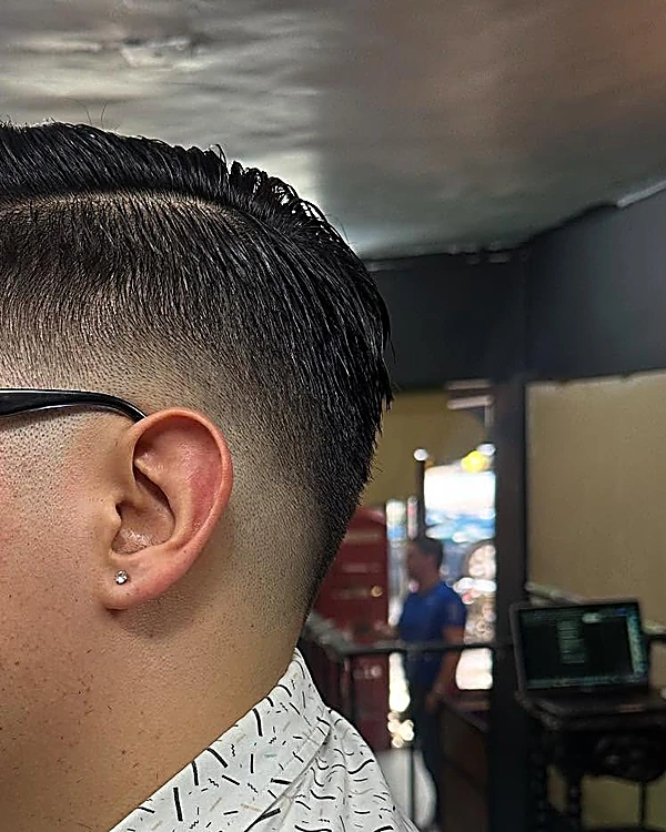 Fade bajo con raya marcada, visto desde atrás de la oreja